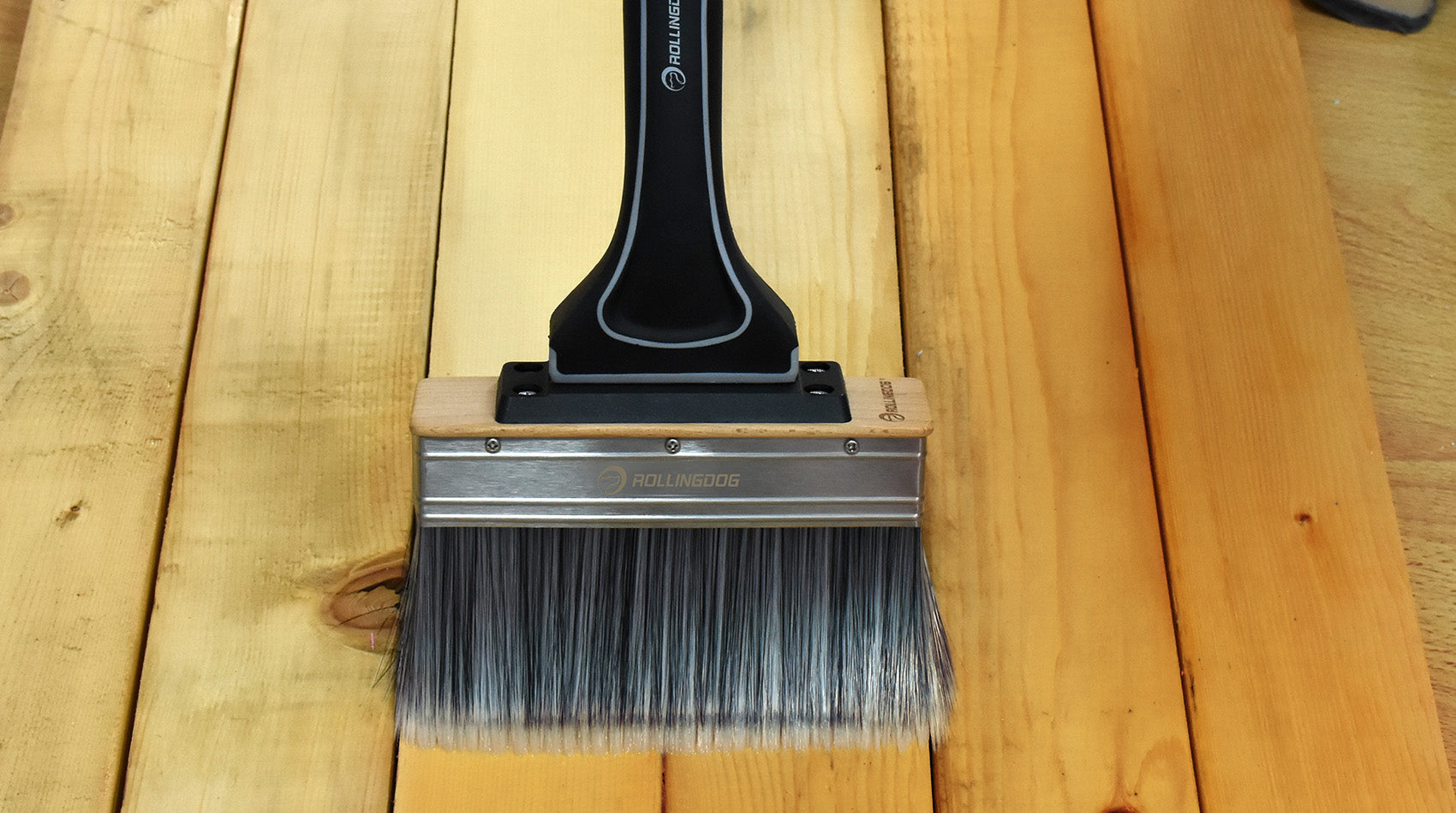 Paint brush with a black handle on a wooden surface