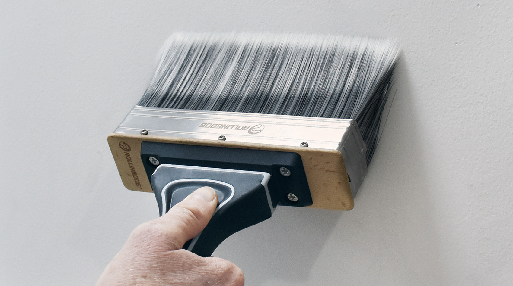 Person using a paintbrush to paint a wall