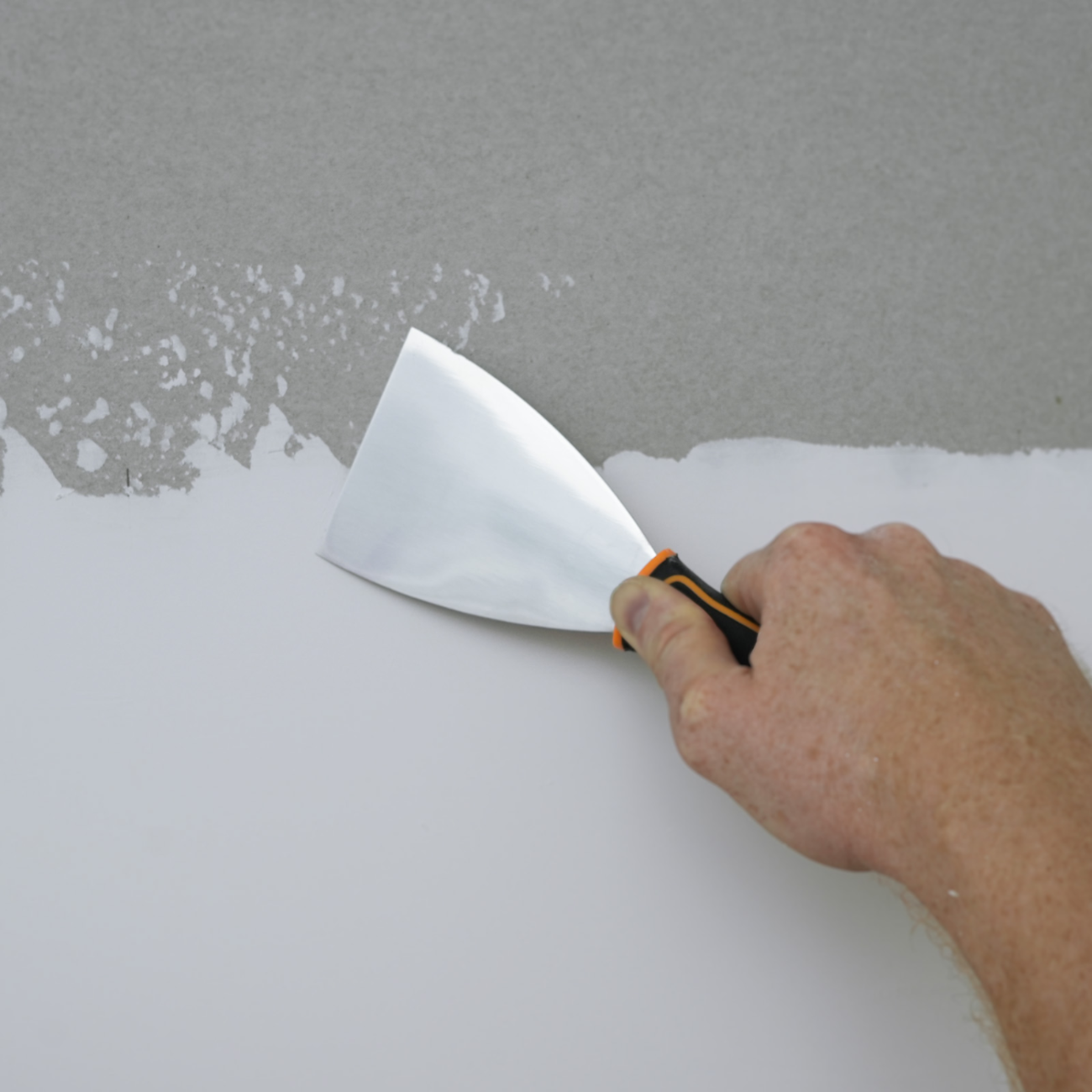 50565-Painter using angled putty knife on a wall