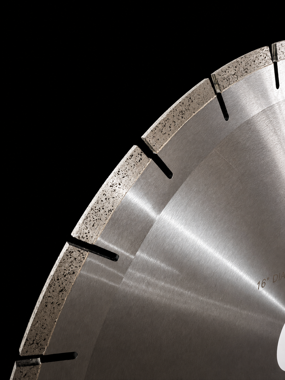 Close-up of a large Diamant-D circular diamond saw blade against a solid black background, showing the metallic silver cutting edge with segmented teeth and a brushed metal surface.
