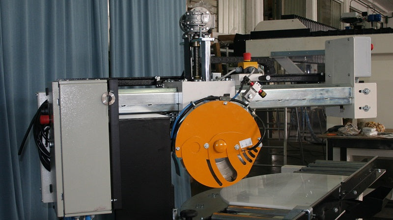 Stone fabricator cutting granite slab on bridge saw in professional shop