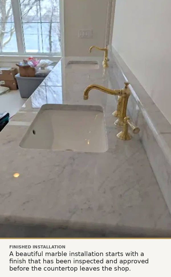 Installed polished marble vanity countertop with undermount sinks and brass faucets