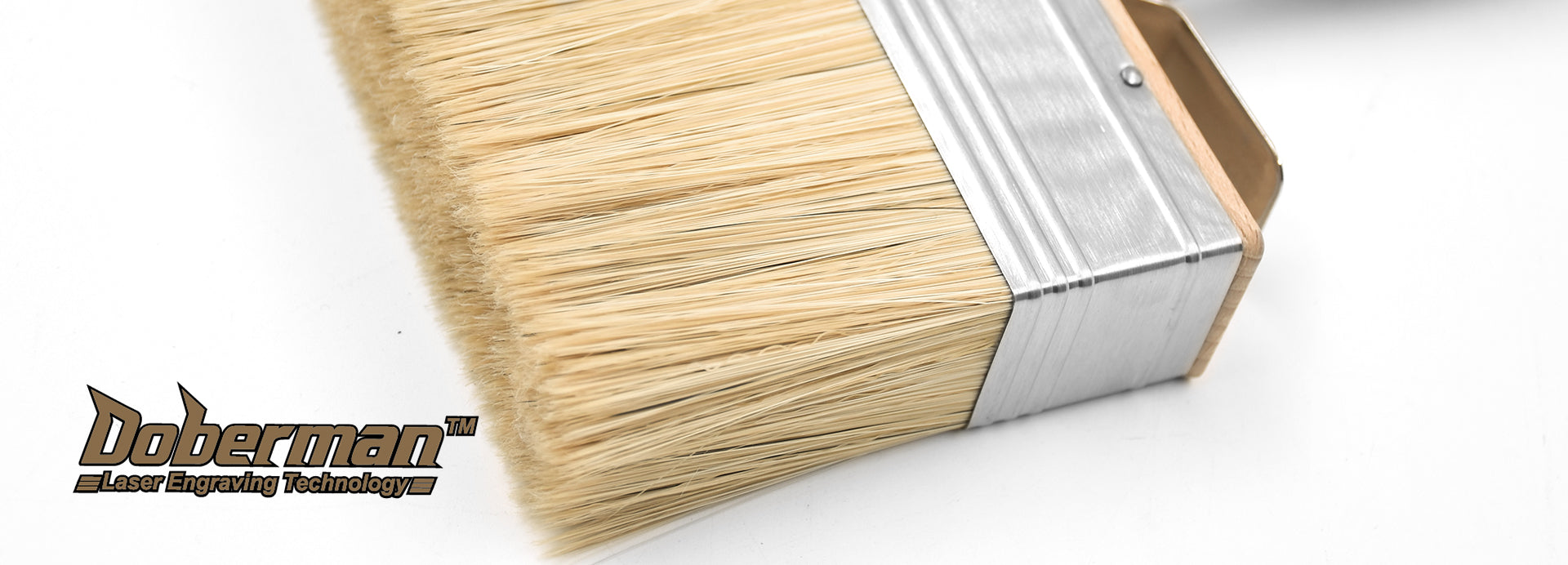Paintbrush with wooden handle and metal ferrule on a white background, featuring the Doberman logo.
