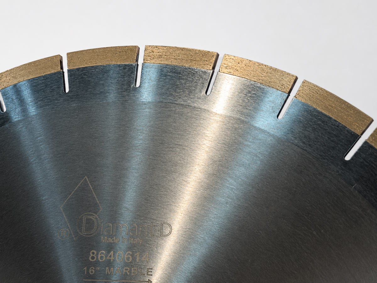 Close-up of a circular diamond saw blade with a brushed silver metal body, segmented cutting edges, and tan diamond segments, showing the brand name Diamant D and model 8640614 on the blade.