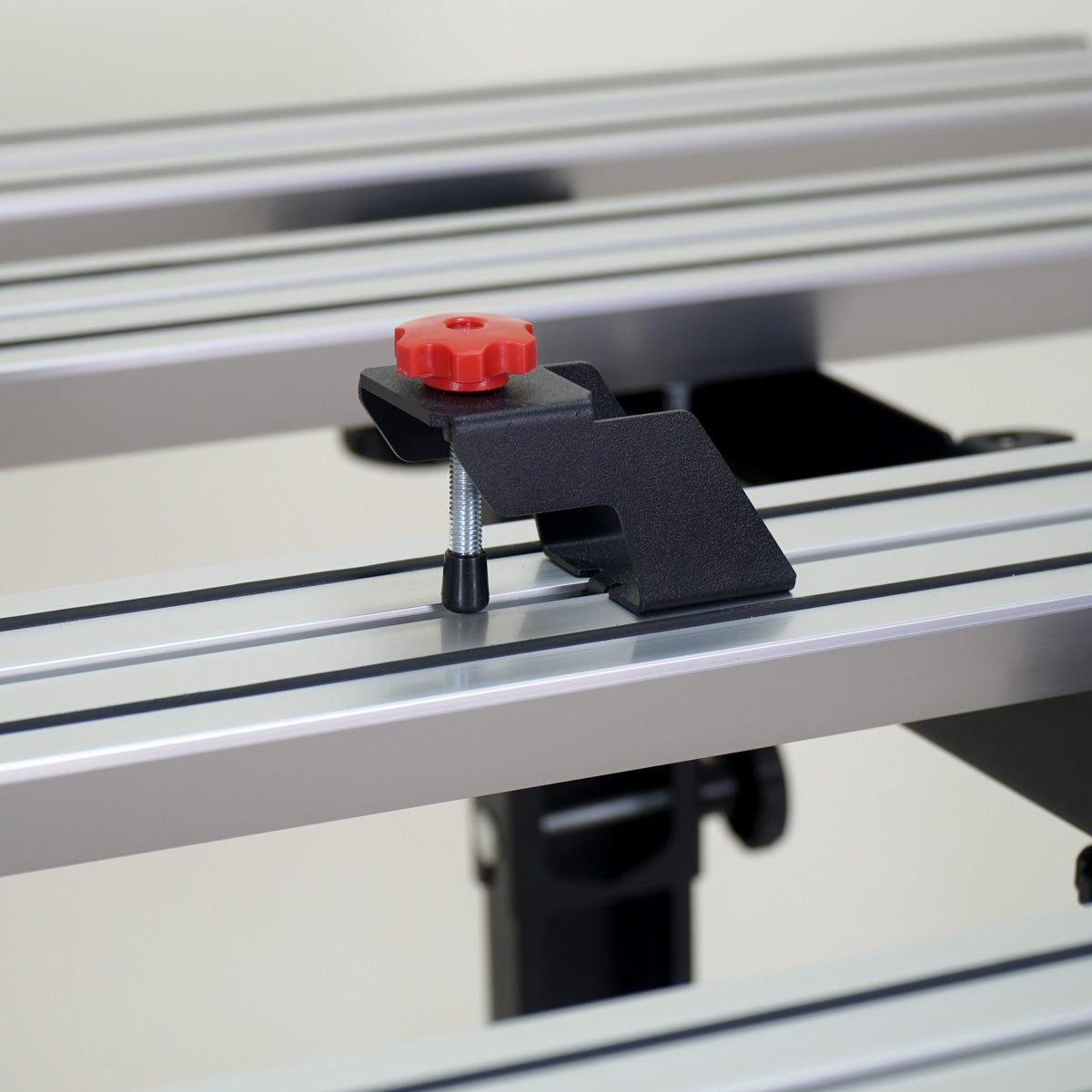 Router table with a clamp and red knob on a white background